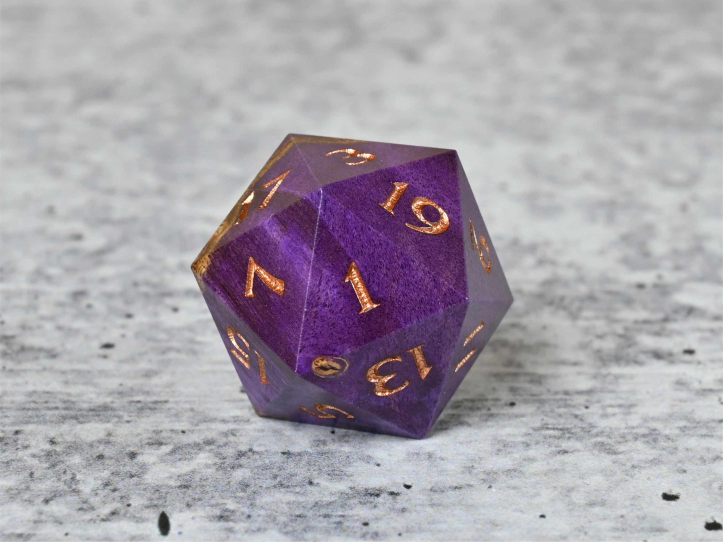 Purple dye stabilized buckeye burl wood d20 with rose gold painted numbers for dnd ttrpg