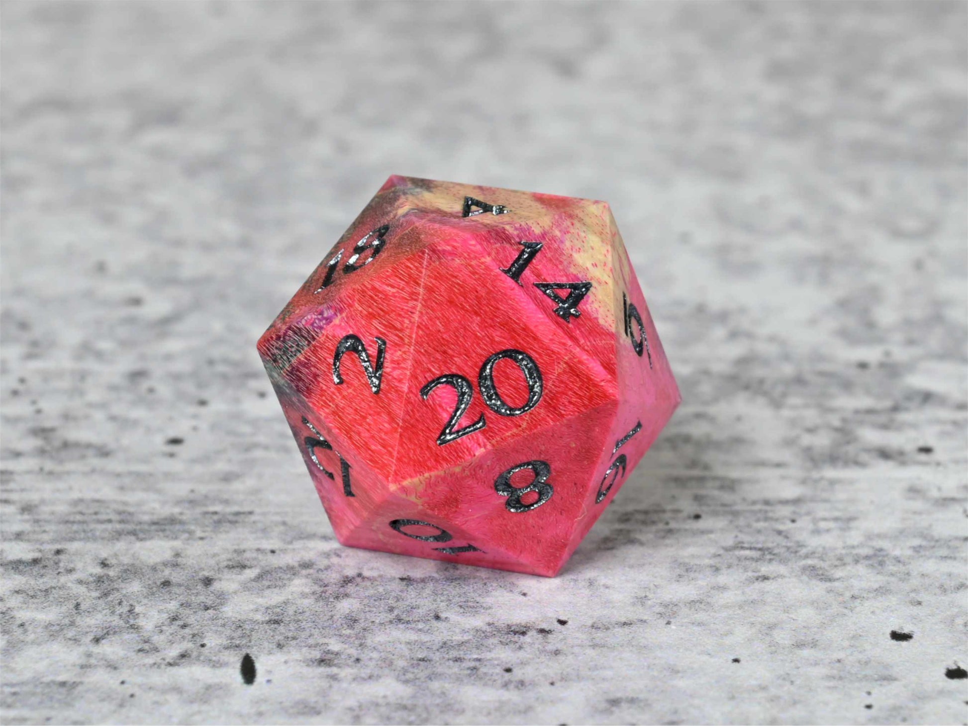 Pink, purple, and blue dye stabilized box elder burl wood d20 with black painted numbers for dnd ttrpg