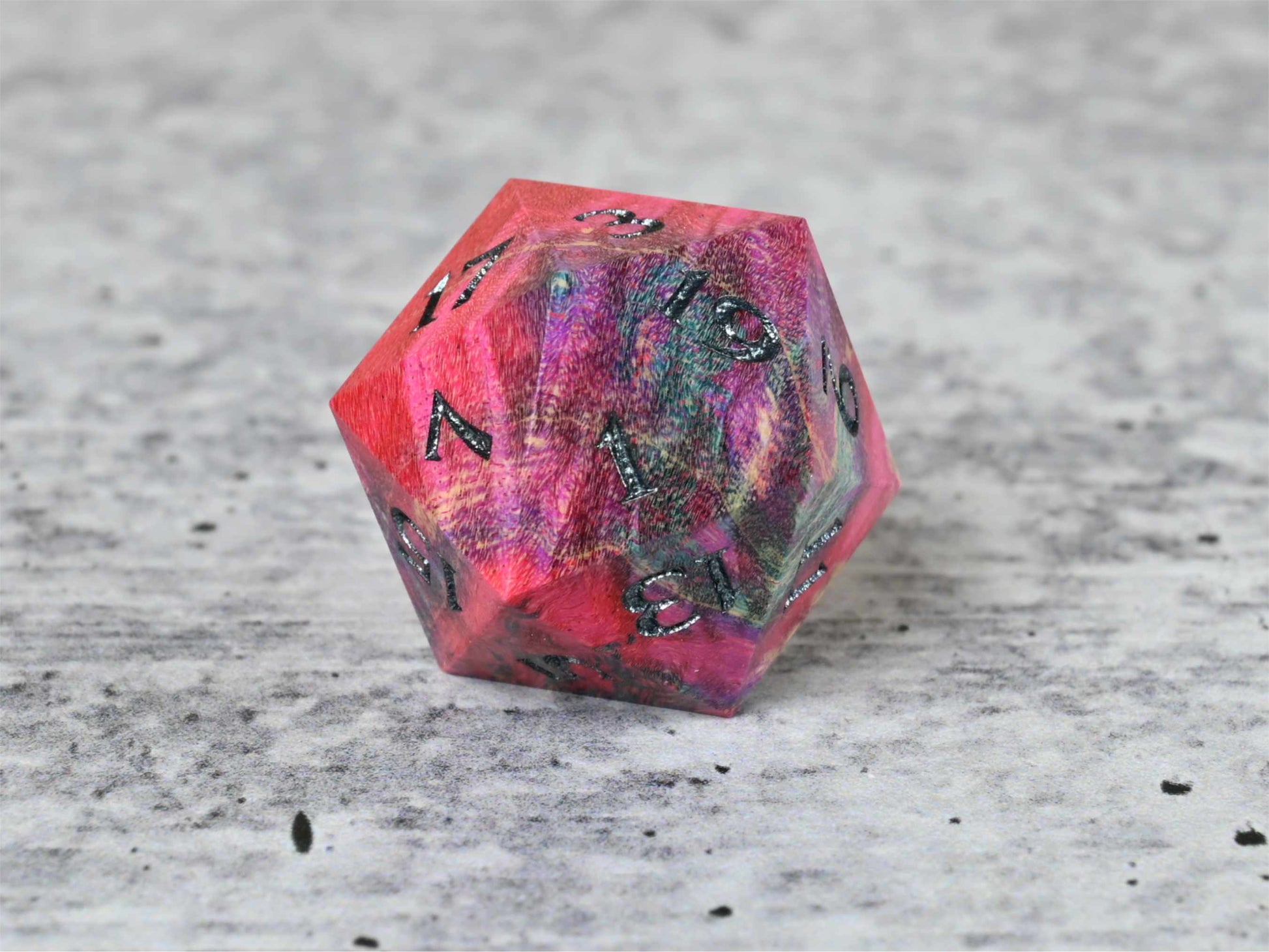 Pink, purple, and blue dye stabilized box elder burl wood d20 with black painted numbers for dnd ttrpg