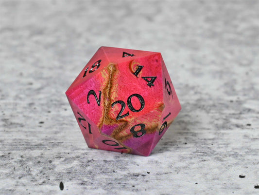 Pink and teal dye stabilized buckeye burl wood d20 with black painted numbers for dnd ttrpg