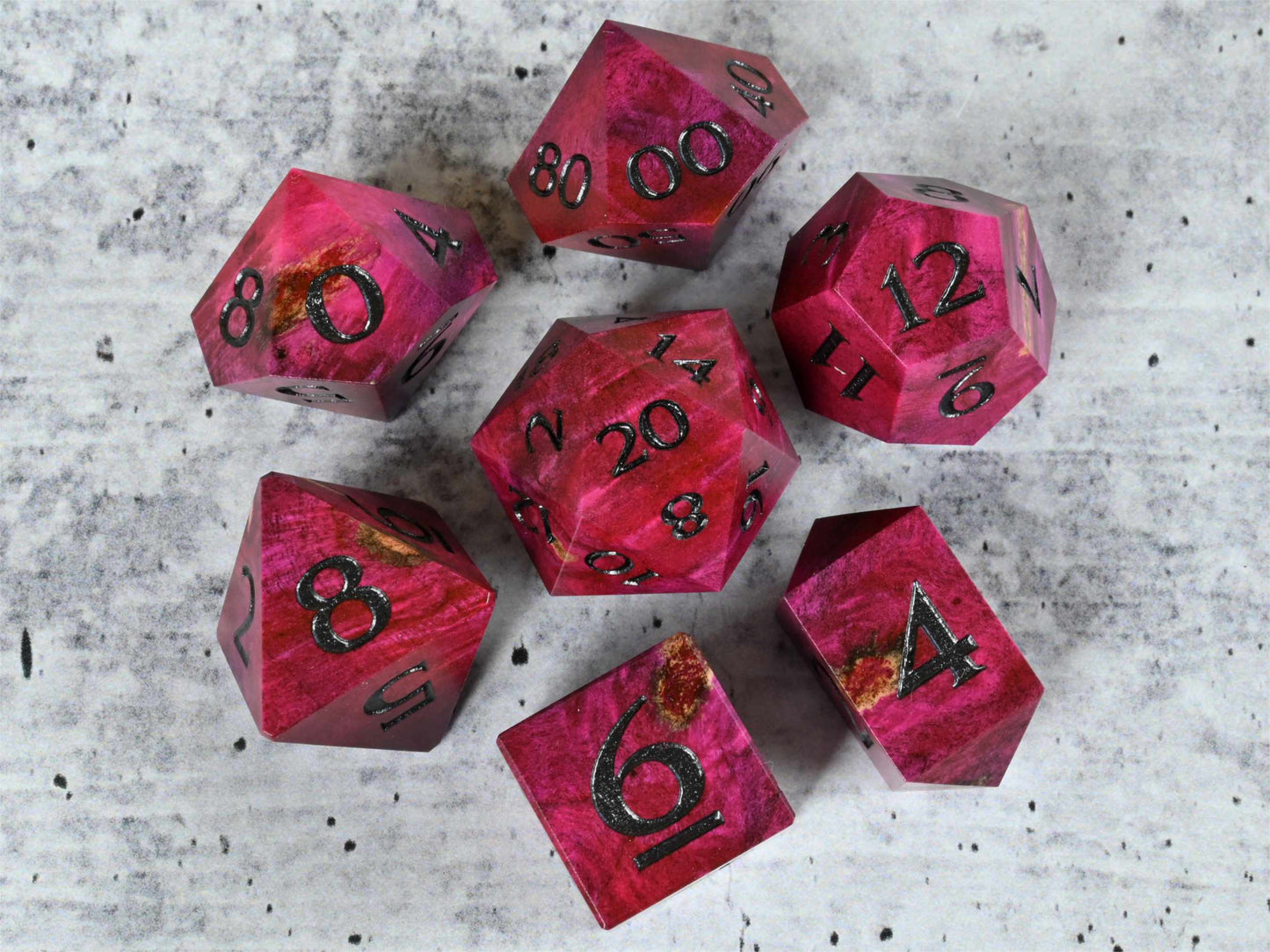 Pink dye stabilized buckeye burl wood dice set with black painted numbers for dnd ttrpg