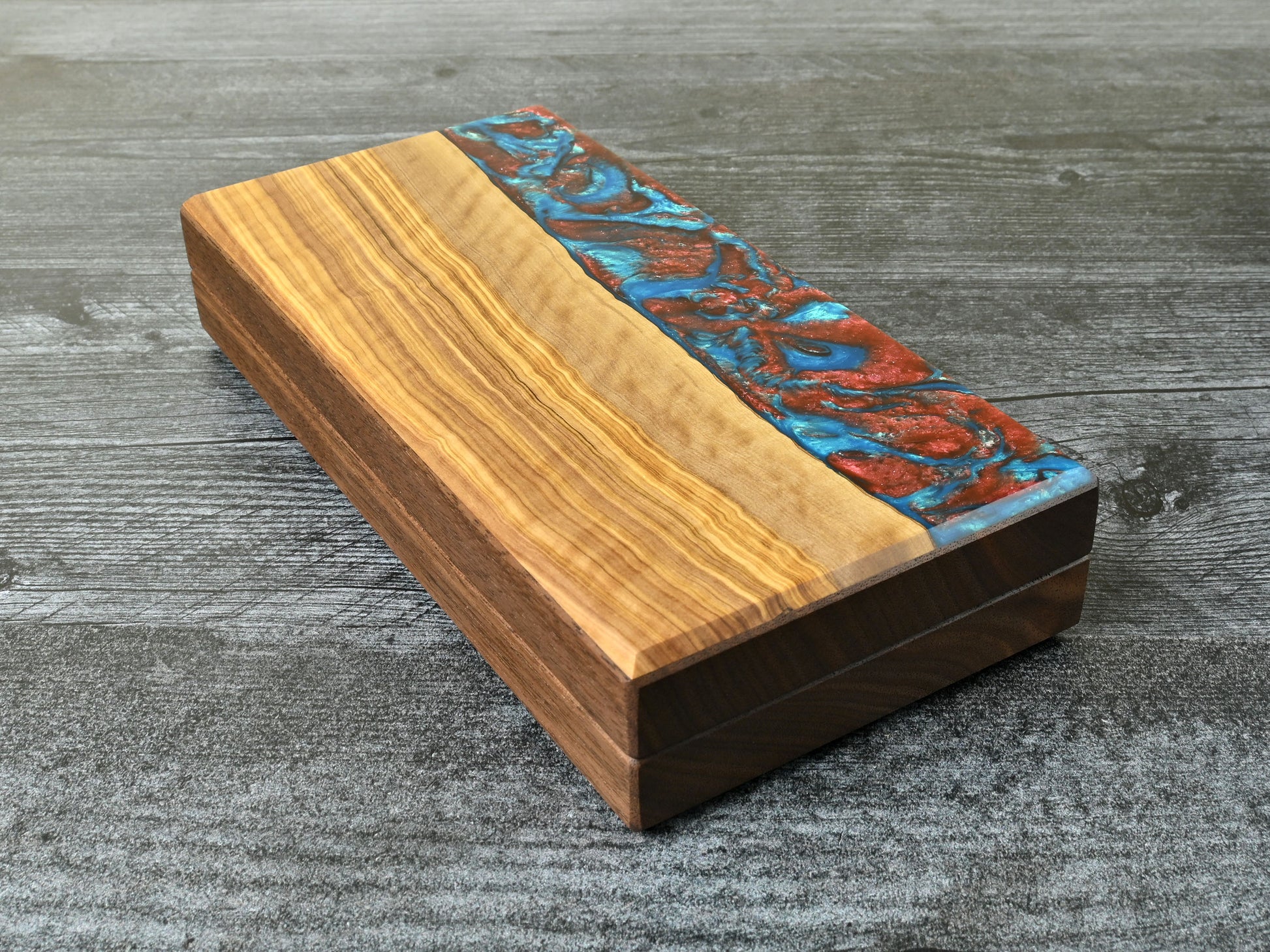 Delver's Kit Dice Box featuring a walnut core and an olivewood top veneer with blue and red resin. Made for D&D ttrpg.
