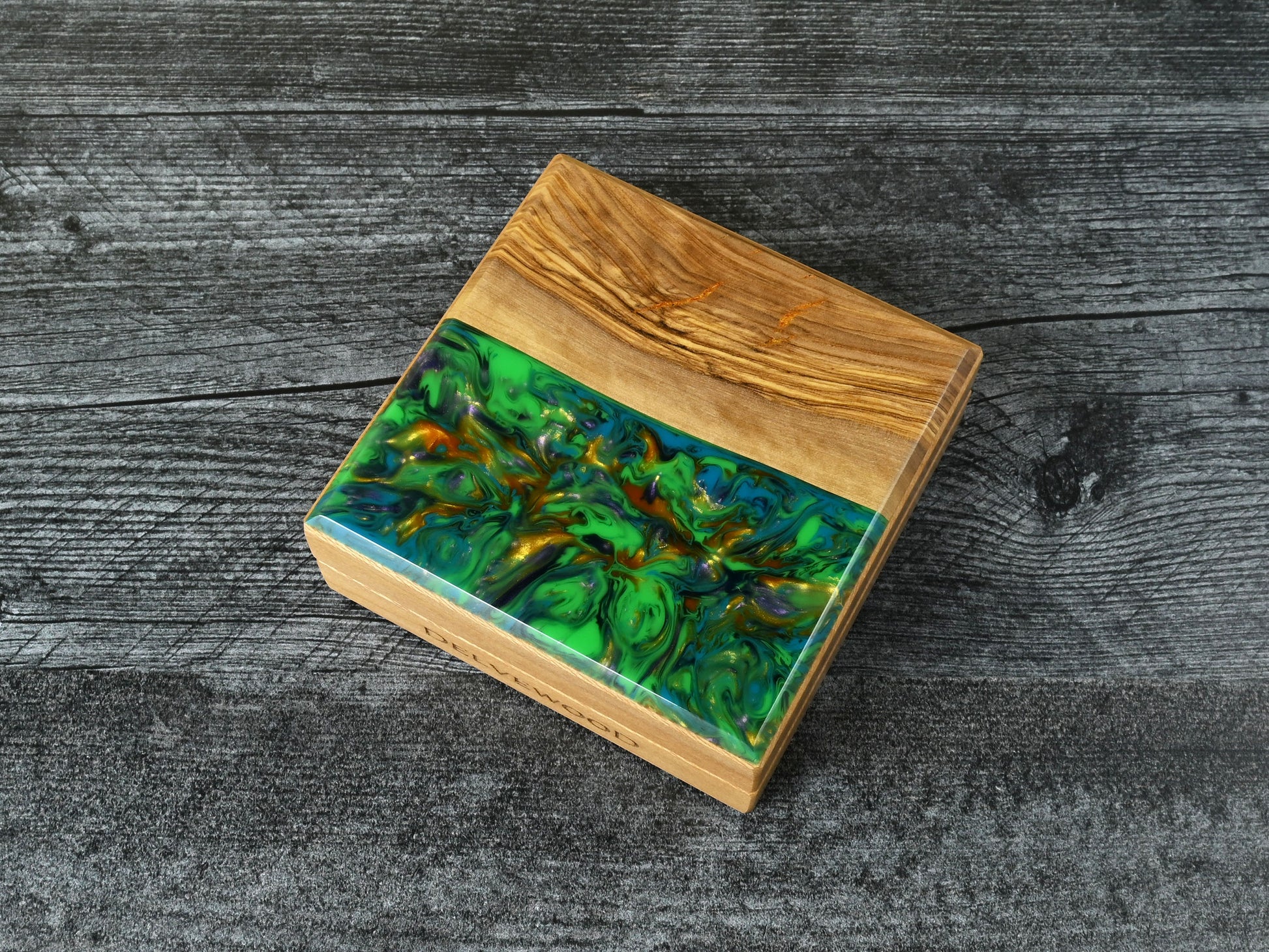 This Little Delver Dice Box features a sycamore wood core and an olivewood top veneer with green, turquoise, purple, and gold resin. D&D ttrpg.