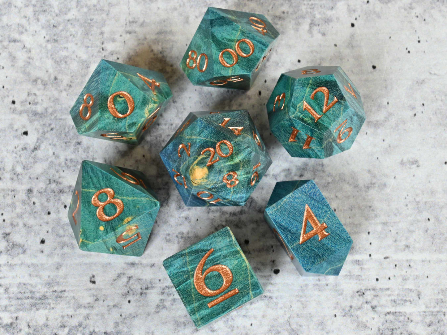Blue and teal dye stabilized box elder burl wood d20 with bronze painted numbers for dnd ttrpg