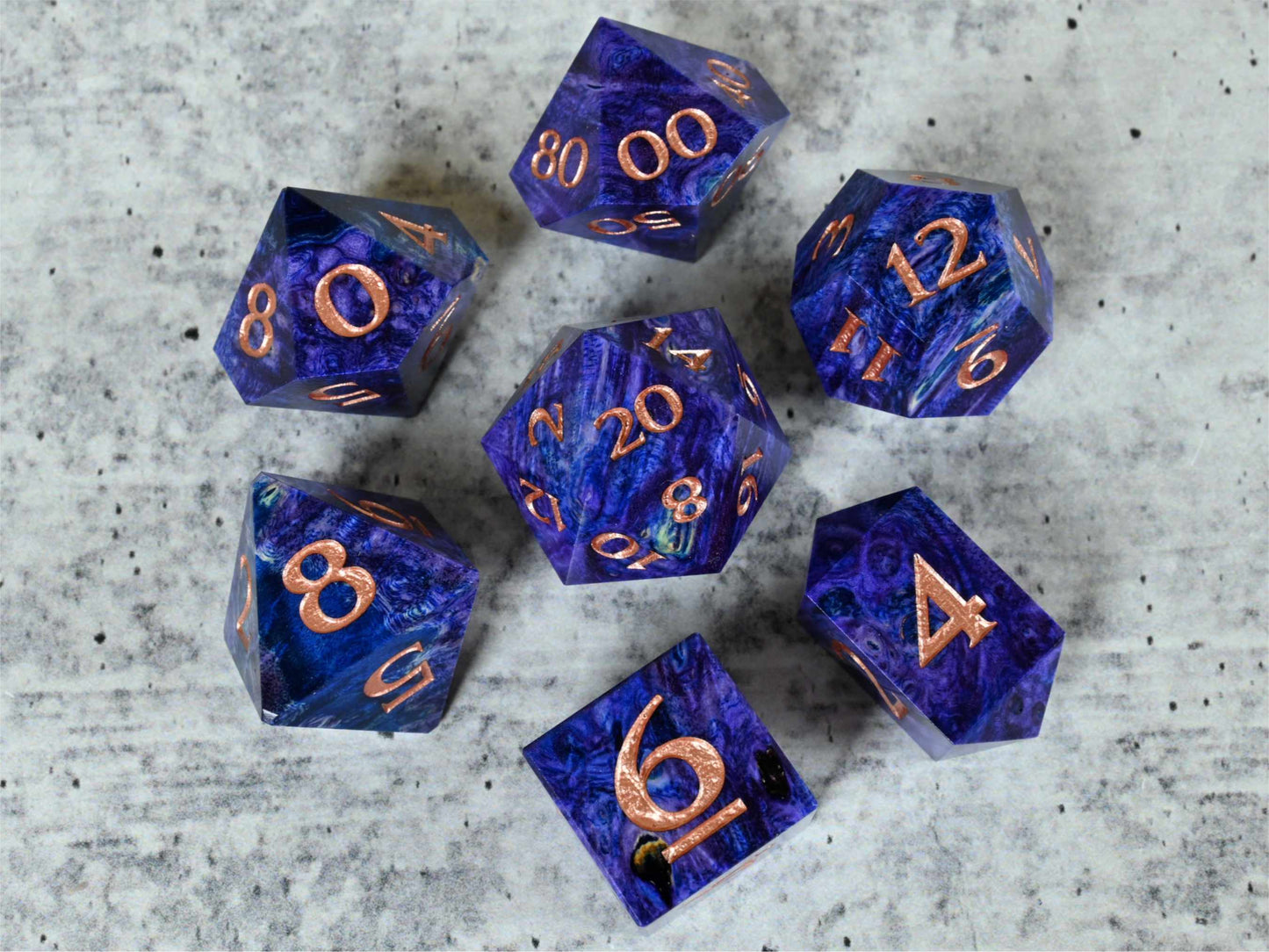 Purple and blue dye stabilized black ash burl wood dice set with rose gold painted numbers for dnd ttrpg