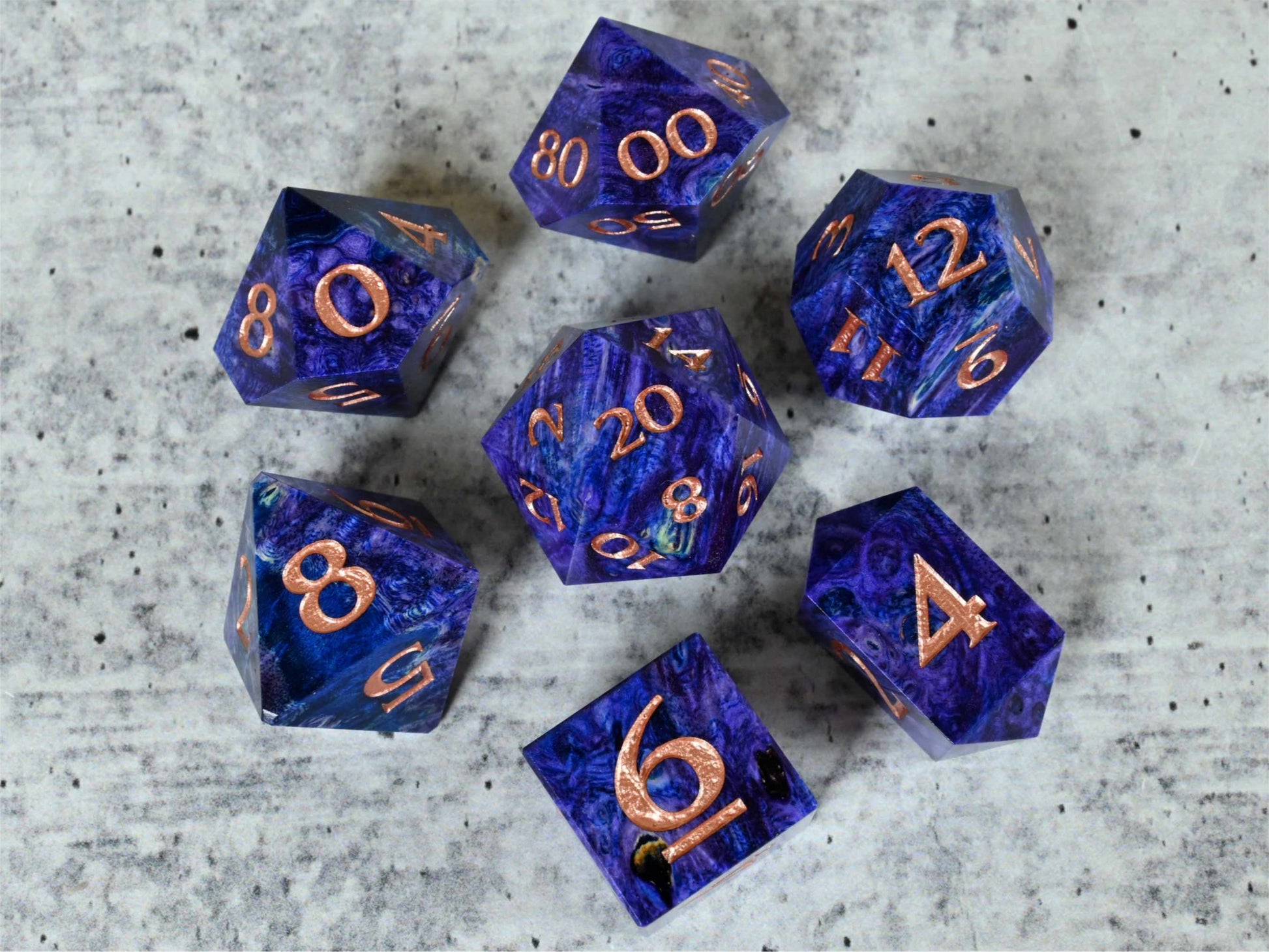 Purple and blue dye stabilized black ash burl wood dice set with rose gold painted numbers for dnd ttrpg