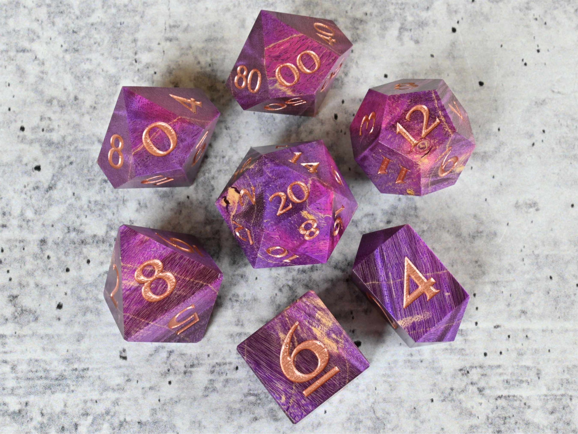 Purple and pink dye stabilized box elder burl wood d20 with rose gold painted numbers for dnd ttrpg