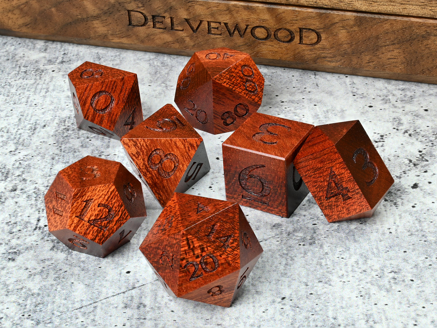 Bloodwood dice set for dnd rpg tabletop gaming in front of Delvewood delver's kit dice box.