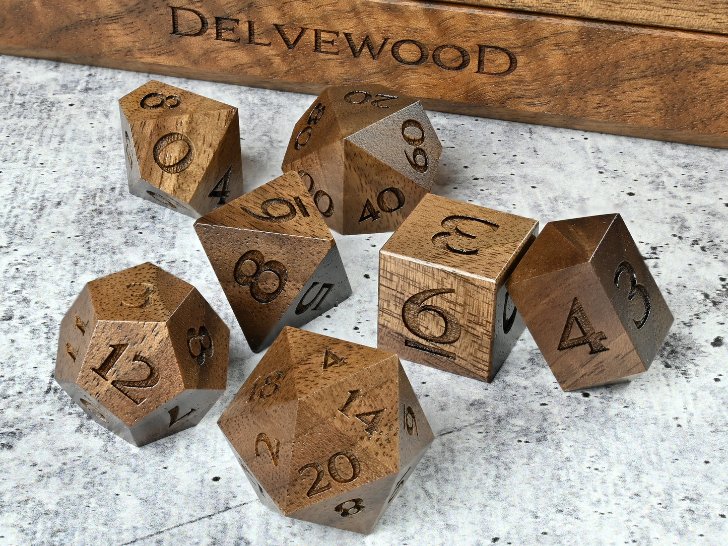 Walnut wood dice set for dnd rpg tabletop gaming in front of Delvewood delver's kit dice box.