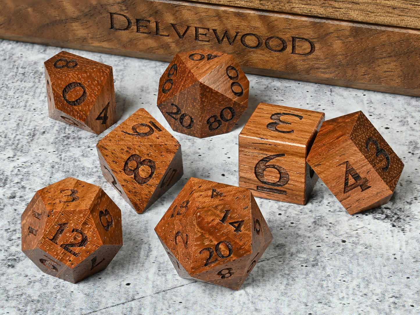 Jatoba wood dice set for dnd rpg tabletop gaming in front of Delvewood delver's kit dice box.