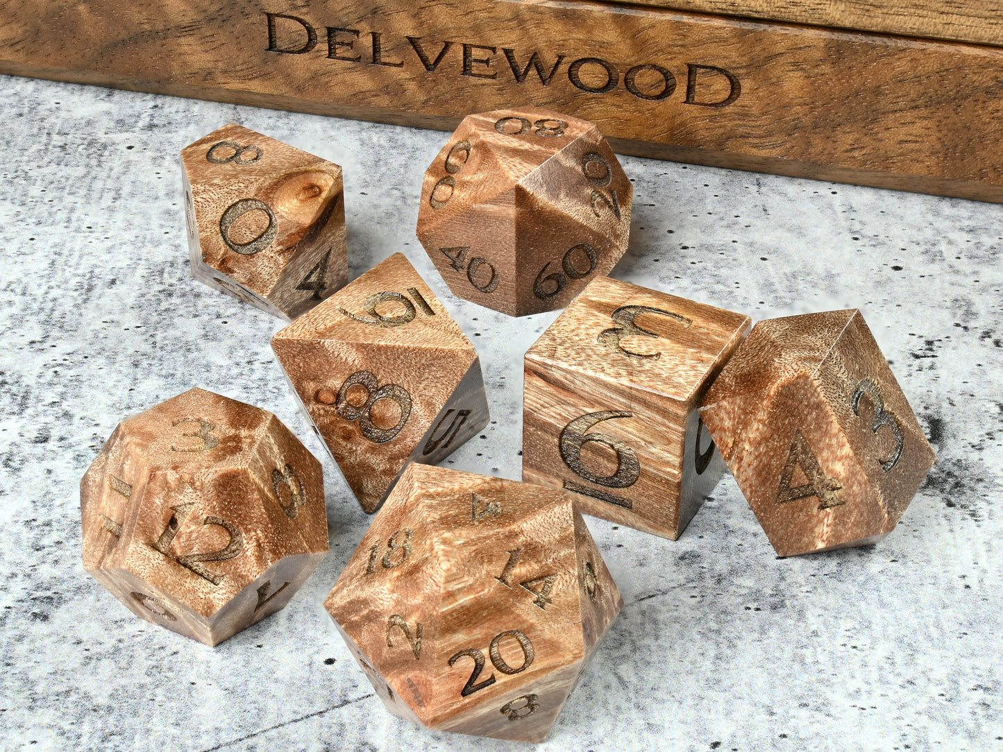 Maple Burl wood dice set for dnd rpg tabletop gaming in front of Delvewood delver's kit dice box.